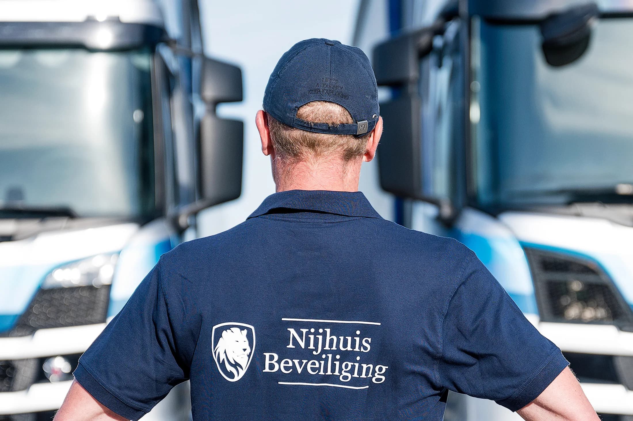 Beveiliger van Nijhuis Beveiliging tussen vrachtwagens op een bedrijventerrein
