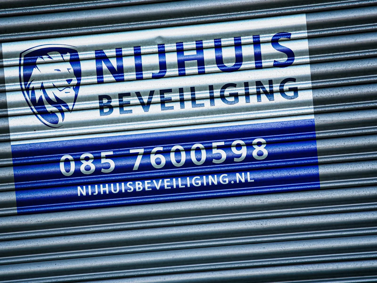 Bord van Nijhuis Beveiliging op een gesloten rolluik