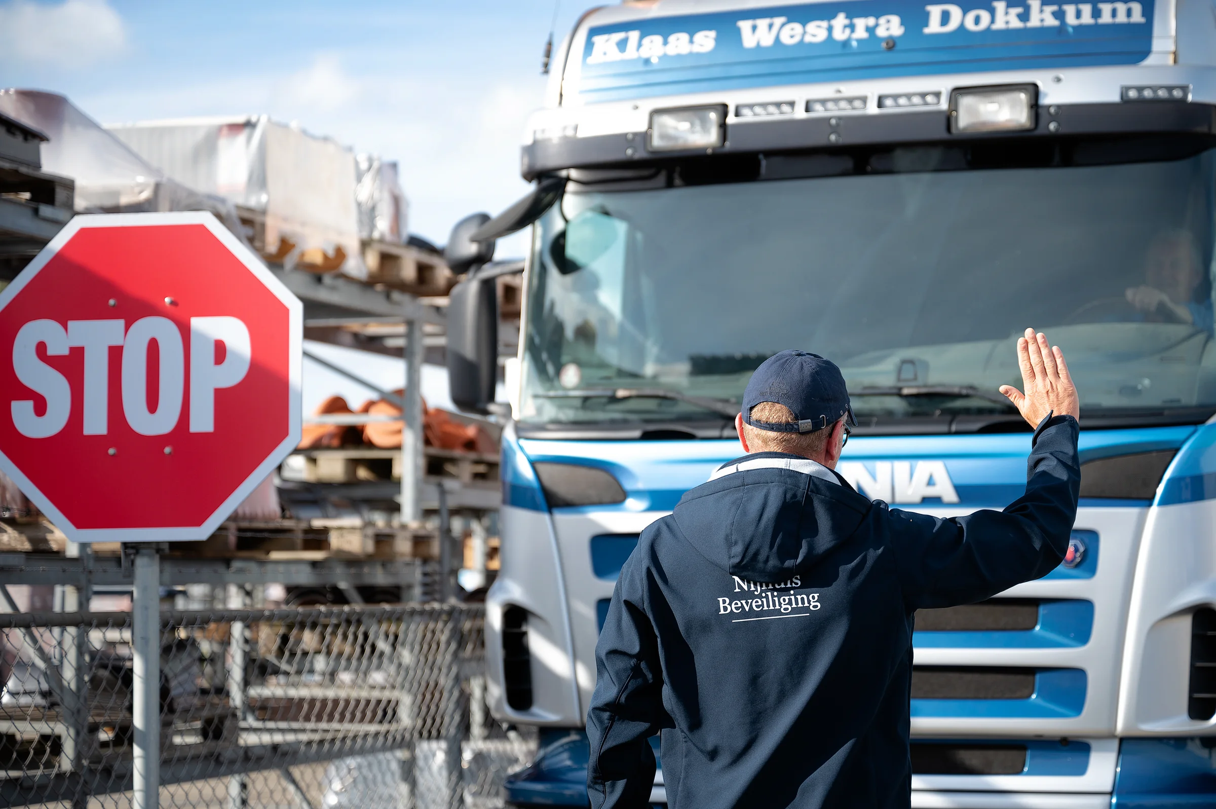Beveiliger van Nijhuis Beveiliging begeleidt verkeer op een bedrijfsterrein